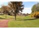 Scenic community path surrounded by lush green grass and trees with Autumn foliage at 19973 N Monte Ln, Maricopa, AZ 85138