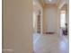 Bright foyer with tile flooring, neutral paint, and a large front door at 19973 N Monte Ln, Maricopa, AZ 85138