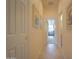 Hallway with neutral walls leads to other rooms, showcasing neutral tile flooring at 19973 N Monte Ln, Maricopa, AZ 85138