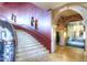 Elegant lobby with ornate staircase, stone arches, and travertine flooring at 19973 N Monte Ln, Maricopa, AZ 85138