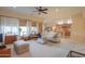 Open concept living room featuring large windows and ceiling fan at 19973 N Monte Ln, Maricopa, AZ 85138
