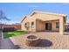 A serene backyard featuring a built in fire pit, synthetic grass and hot tub at 2009 E Lindrick Dr, Gilbert, AZ 85298