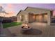 An inviting backyard with a built in fire pit, synthetic grass and a hot tub at 2009 E Lindrick Dr, Gilbert, AZ 85298