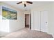 Bedroom featuring carpet floors, ceiling fan, closet, and a decorative desert landscape painting at 2009 E Lindrick Dr, Gilbert, AZ 85298