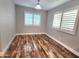 Bedroom with wood-look floors and bright, shuttered windows at 2009 E Lindrick Dr, Gilbert, AZ 85298