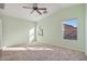 A light green bedroom with two windows, neutral carpet, and a ceiling fan at 2009 E Lindrick Dr, Gilbert, AZ 85298