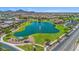 Community pond surrounded by a grassy area and residential houses at 2009 E Lindrick Dr, Gilbert, AZ 85298
