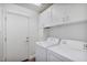 Convenient laundry room with modern washer and dryer units, ample storage, and access door at 2009 E Lindrick Dr, Gilbert, AZ 85298