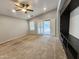 Bright living room features neutral carpeting, vaulted ceilings, sliding glass doors, and a built-in entertainment center at 2009 E Lindrick Dr, Gilbert, AZ 85298