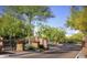 Community entry gate with brick pillars, desert landscaping, and red flowers under a blue sky at 20100 N 78Th Pl # 2210, Scottsdale, AZ 85255