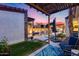 Spacious backyard featuring a pool, outdoor kitchen, covered seating area, and lush landscaping at 20125 E Via Del Rancho --, Queen Creek, AZ 85142