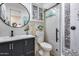 Bathroom featuring a dark vanity, round mirror, tiled shower, and toilet at 20125 E Via Del Rancho --, Queen Creek, AZ 85142
