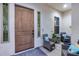 Inviting covered entry with a rustic wood door, seating area, and decorative blue accent pillows at 20125 E Via Del Rancho --, Queen Creek, AZ 85142