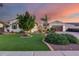 Beautifully landscaped front yard with lush green grass, mature trees, and a charming white stucco home at 20125 E Via Del Rancho --, Queen Creek, AZ 85142