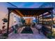 Inviting covered outdoor seating area with stone fireplace and lush plants at 20125 E Via Del Rancho --, Queen Creek, AZ 85142