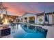 Stunning backyard pool with a fire pit feature, a covered patio, and manicured landscaping under a colorful sky at 20125 E Via Del Rancho --, Queen Creek, AZ 85142