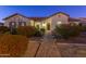 Nighttime view of a single-story home showcasing its inviting front yard and well-lit walkway at 22695 S 220Th St, Queen Creek, AZ 85142