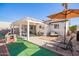 Backyard featuring a covered patio, lush green turf, and outdoor seating at 2320 E Harvard St, Phoenix, AZ 85006