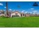 Spacious backyard featuring a covered patio and lush green lawn at 2359 W Del Oro Cir, Mesa, AZ 85202