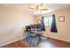 Bright bedroom with wood floors, ceiling fan, and large window with natural light at 2359 W Del Oro Cir, Mesa, AZ 85202
