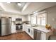 Modern kitchen features stainless steel appliances, granite countertops, and white cabinets, offering ample counter space at 2359 W Del Oro Cir, Mesa, AZ 85202