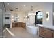 Bright bathroom with white freestanding tub, marble countertops, wood cabinets, and modern light fixtures at 23779 N 91St St, Scottsdale, AZ 85255