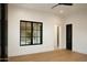 Bedroom featuring wood floors, a black window, arched doorway, and black door at 23779 N 91St St, Scottsdale, AZ 85255