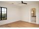 Bedroom with wood floors, a dark-framed window, and access to an ensuite bathroom at 23779 N 91St St, Scottsdale, AZ 85255