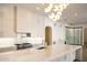 Bright, open kitchen with island, gas range, marble counters, and glass enclosed wine cellar at 23779 N 91St St, Scottsdale, AZ 85255