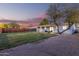 Spacious backyard with a large tree, a well-maintained lawn, and a covered patio, enhancing outdoor living at 2418 W Flower St, Phoenix, AZ 85015