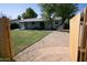 Backyard view features a well-manicured lawn, mature tree, and covered patio, ideal for outdoor entertaining at 2418 W Flower St, Phoenix, AZ 85015