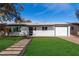 Charming single-story home featuring a well-manicured lawn and a welcoming walkway to the front door at 2418 W Flower St, Phoenix, AZ 85015