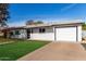 Exterior view of a single story home featuring an attached garage and landscaped front yard at 2418 W Flower St, Phoenix, AZ 85015