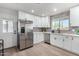 Modern kitchen with stainless steel appliances, white cabinets, and sleek backsplash at 2418 W Flower St, Phoenix, AZ 85015