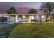 Covered patio with an outdoor seating area, offering a relaxing space overlooking the spacious backyard at 2418 W Flower St, Phoenix, AZ 85015