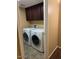 Laundry room featuring dark cabinets, tile floor, and a washer and dryer at 25532 W Williams W St, Buckeye, AZ 85326