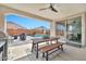 Covered back patio overlooking the pool with a dining table and barbecue at 25945 W Sands Dr, Buckeye, AZ 85396