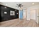 Bedroom with a black accent wall, ceiling fan, and a blue barn door leading to the bathroom, creating an inviting space at 25945 W Sands Dr, Buckeye, AZ 85396