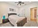 Bright bedroom featuring gray carpet, ceiling fan, and ensuite bathroom with modern fixtures at 25945 W Sands Dr, Buckeye, AZ 85396