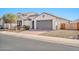 Charming home featuring a neutral color scheme, tile roof, well-kept landscaping, and a gray two-car garage at 25945 W Sands Dr, Buckeye, AZ 85396
