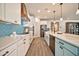 Well-lit kitchen featuring white and blue cabinets, stainless steel appliances, and ample counter space at 25945 W Sands Dr, Buckeye, AZ 85396