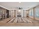 Spacious living room with wood-look flooring, a fireplace, and large windows creating a bright and inviting space at 25945 W Sands Dr, Buckeye, AZ 85396
