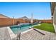 Backyard pool with a waterfall feature, artificial grass, two lounge chairs, and a privacy fence at 25945 W Sands Dr, Buckeye, AZ 85396
