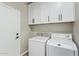 Functional laundry room with white cabinetry and modern washer and dryer at 3621 W Keller Ct, Anthem, AZ 85086