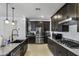 Modern kitchen featuring dark cabinetry, stainless steel appliances, and granite countertops at 36602 W San Alvarez Ave, Maricopa, AZ 85138