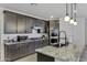 Modern kitchen with stainless steel appliances, granite countertops, and dark wood cabinetry at 36602 W San Alvarez Ave, Maricopa, AZ 85138