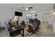 Comfortable living room featuring a ceiling fan, carpet floors, and natural light at 36602 W San Alvarez Ave, Maricopa, AZ 85138