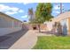 Inviting backyard featuring a concrete patio, outdoor fireplace, and mature trees, ready for gatherings and relaxation at 416 W Chambers St, Phoenix, AZ 85041