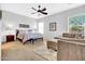 Spacious bedroom with neutral colors and an adjacent sitting area at 42823 N Courage Trl, Anthem, AZ 85086