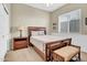 Bedroom with a large bed, bench, side table, and a window that provides natural lighting at 42823 N Courage Trl, Anthem, AZ 85086